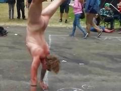 Naked guy walking on hands at festival