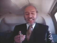 Old bearded man in a suit getting head in a helicopter