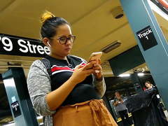 Cute chubby Filipina girl with glasses waiting for train